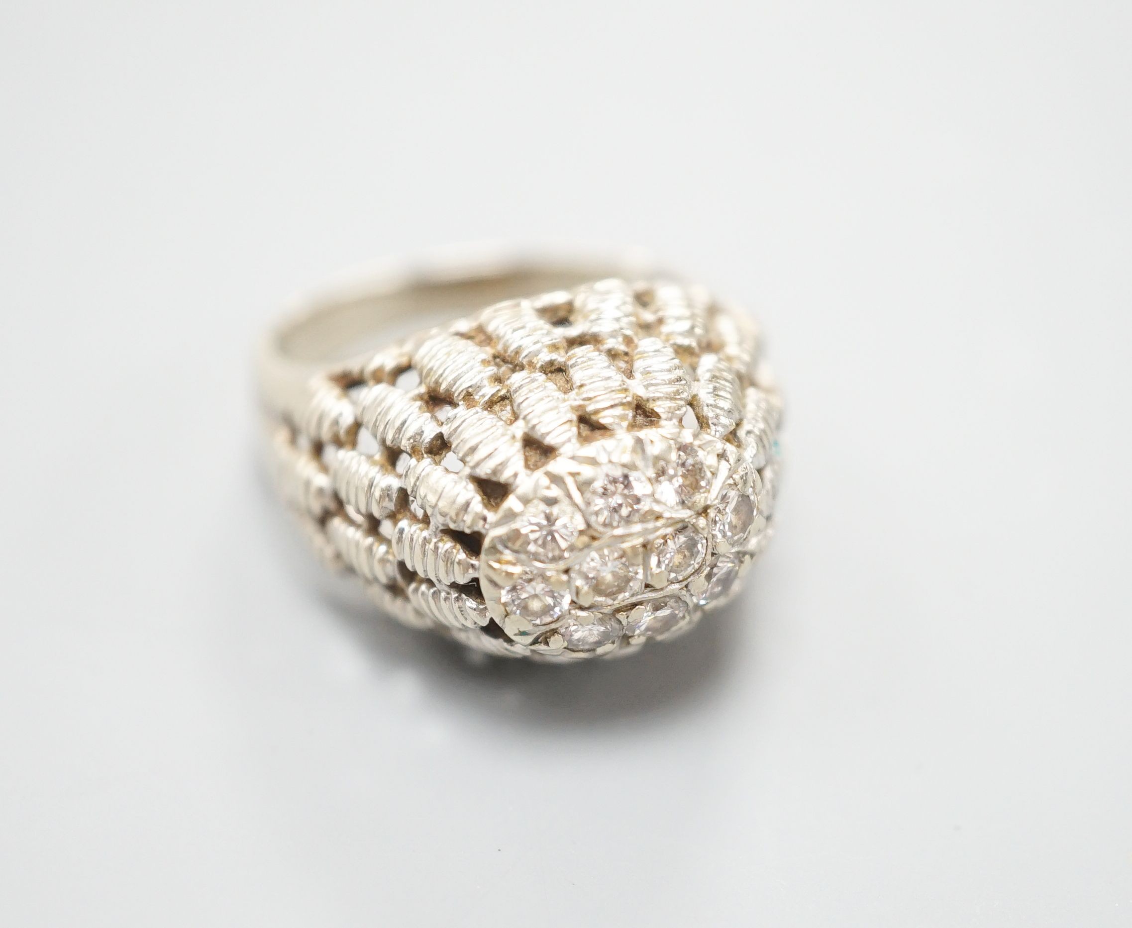 A continental textured white metal and diamond cluster set domed top dress ring, size K/L, gross weight 5.5 grams.